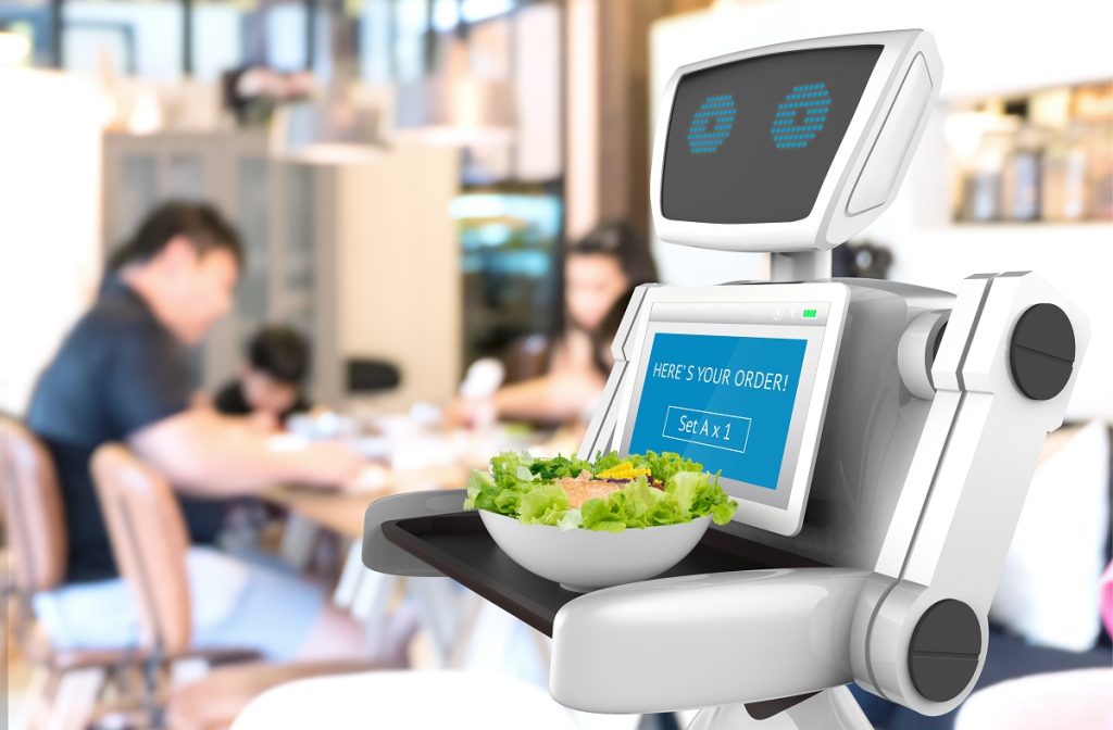 Robot w restauracji dostarcza do stolika zamówienie. 